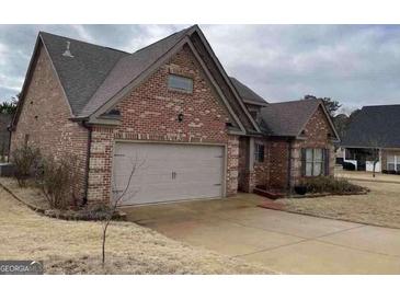 Traditional brick home with attached garage and well-maintained lawn at 3349 Alhambra Cir, Hampton, GA 30228