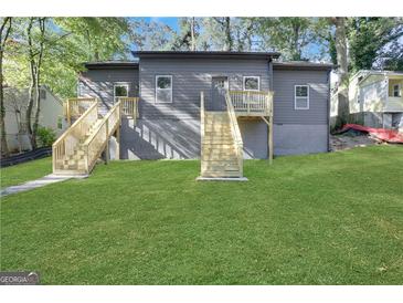 Gray home featuring a lush lawn and two sets of wooden stairs leading to elevated entrances at 1226 Byewood Sw Ln, Atlanta, GA 30310