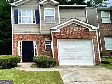 Charming two-story home with brick accents and a well-manicured front yard at 5057 Windsor Forrest Lane, Atlanta, GA 30349