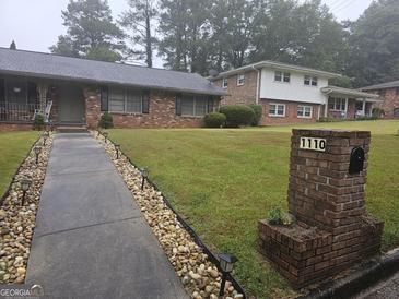 Charming single-story home with a well-manicured lawn and welcoming walkway at 1110 Hilburn Se Dr, Atlanta, GA 30316