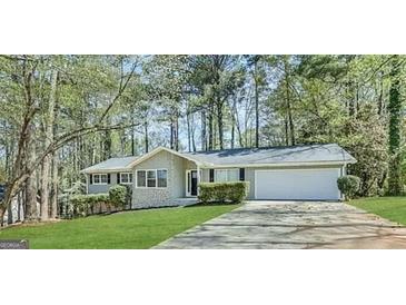 Charming ranch-style home featuring a manicured front yard and attached two-car garage at 530 Valley Woods Se Cir, Conyers, GA 30094