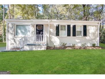 Charming single-story home with white brick, black shutters, manicured lawn, and a welcoming front entrance at 914 Mercury Nw Dr, Atlanta, GA 30331