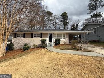Charming single-story home with a brick facade, well-maintained front yard, and a convenient covered carport at 1068 Longshore Dr, Decatur, GA 30032