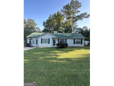 Charming single-story home featuring a green metal roof and well-maintained lawn at 517 Pebble Pt, Loganville, GA 30052