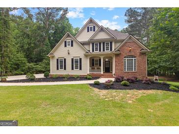 Charming two-story home with a manicured lawn and inviting curb appeal with mature trees at 155 Carrolls Way, Fayetteville, GA 30215