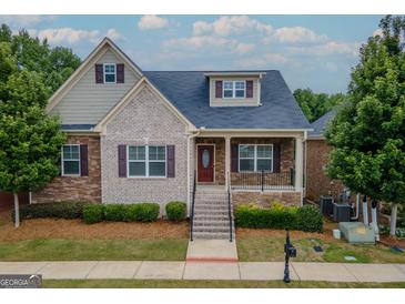 Charming brick and siding home with landscaped front yard and inviting front porch at 2047 Gazebo Ln, Snellville, GA 30078