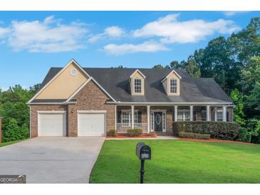 Charming brick home with a two-car garage, long porch, and well-manicured lawn at 185 Stewart Glen Dr, Covington, GA 30014