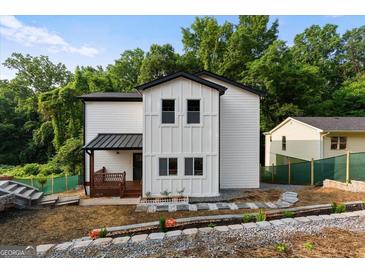 Charming two-story home featuring white siding, black trim, and a cozy front porch at 2328 Lakewood Ave Sw, Atlanta, GA 30315