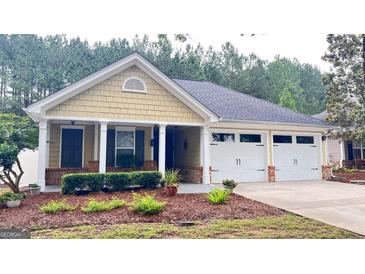 Charming home featuring a well-manicured front yard and a two-car garage at 155 Cottage Club Dr, Locust Grove, GA 30248