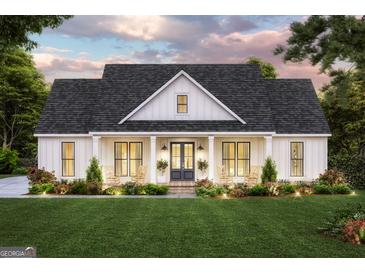 Charming one-story home with a welcoming front porch, rocking chairs, and manicured landscaping at 380 Ayers Rd, Bowdon, GA 30108