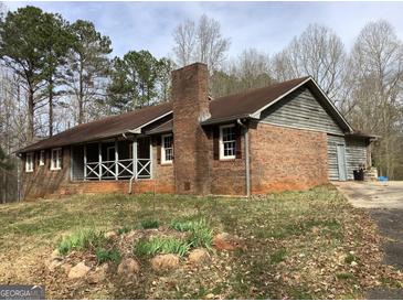 Charming brick home with a cozy screened in porch and a stone chimney at 13370 Panhandle Rd, Hampton, GA 30228