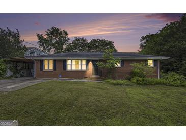 Charming single-story brick home featuring a well-maintained lawn and a cozy, inviting facade at dusk at 734 Meadowlark Dr, Villa Rica, GA 30180