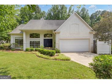 Charming single-story stucco home with lush front yard and attached two-car garage at 111 Kenton Pl, Peachtree City, GA 30269
