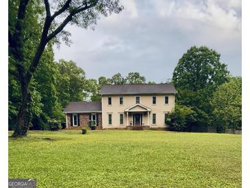 Charming two-story home with a big lawn and mature trees, perfect for outdoor activities at 524 Westbridge Dr, Fayetteville, GA 30214