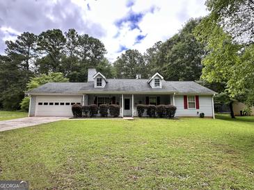 Charming one-story home with attached garage and well-manicured lawn at 150 Willow Shoals Dr, Covington, GA 30016