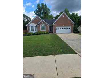 Charming single-Gathering home featuring a well-manicured lawn and a two-car garage at 1925 Cedar Walk Ln, Conley, GA 30288