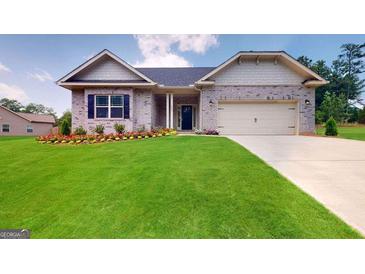 Charming single-story home with manicured lawn and beautiful flower beds at 263 Eason St, Bowdon, GA 30108