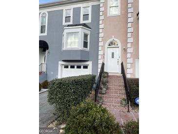 Charming townhome boasts a brick stairway leading to a white door, complemented by gray and peach facade at 3745 Meeting St, Duluth, GA 30096