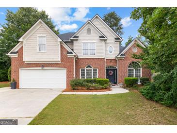 Charming two-story brick home with a manicured lawn and attached two-car garage at 1602 Cascade Overlook, Peachtree City, GA 30269