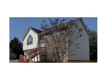 Charming home with a two car garage, brick and vinyl siding, and a stairway leading to the front door at 7101 Brecken Pl, Lithonia, GA 30058