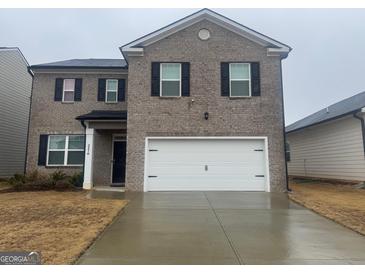 Traditional two-story home featuring a large two-car garage and neutral brick facade at 2276 Waycross Ln # 21, Dacula, GA 30019