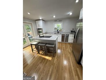 Modern kitchen features a marble island with seating and stainless steel appliances at 242 Adair St, Decatur, GA 30030