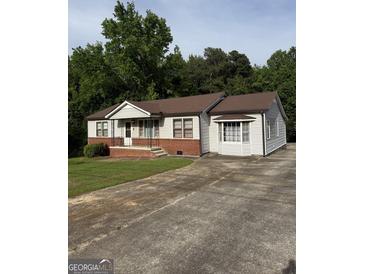 Charming single-story home with gray siding, brick accents, and a spacious concrete driveway at 5225 Silhouette Sw Ln, Mableton, GA 30126