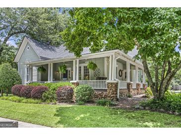 Charming home boasts a large, inviting wraparound porch and beautiful landscaping at 3119 Conyers Se St, Covington, GA 30014