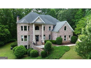 Stunning brick home with manicured landscaping and mature trees at 115 Robinwood Ct, Fayetteville, GA 30214