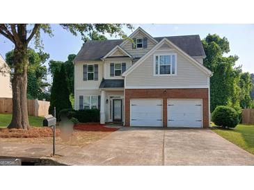 Charming two-story home with a brick-accented two-car garage and well-maintained landscaping at 7069 Littlebrook Way, Douglasville, GA 30134