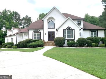 Stately home featuring a well-manicured lawn, sculpted bushes, and a private driveway at 130 Victoria Pl, Fayetteville, GA 30214