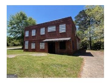 Two-story brick building with a dark awning shading the front entrance at 889 W Hightower Trl, Social Circle, GA 30025