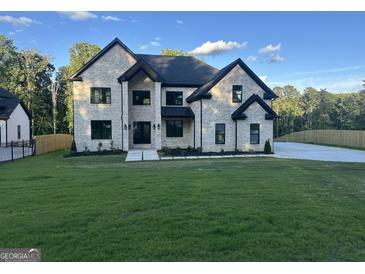 Beautiful white brick home featuring black trim, a well manicured lawn, and a contemporary design at 1291 E M Croy Rd, Sugar Hill, GA 30518