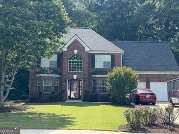 Charming two-story brick home with a well-manicured lawn and attached two-car garage at 1028 Gloria Grand Blvd, Mcdonough, GA 30252