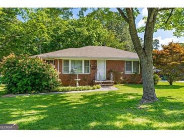 Charming brick home with well-maintained lawn, mature landscaping, and inviting curb appeal at 1070 Elaine Dr, Forest Park, GA 30297