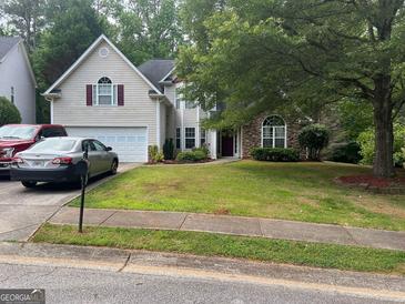Charming two-story home with a well-manicured lawn, stone accents, and an attached two-car garage at 5327 Yoshino Ter, Powder Springs, GA 30127