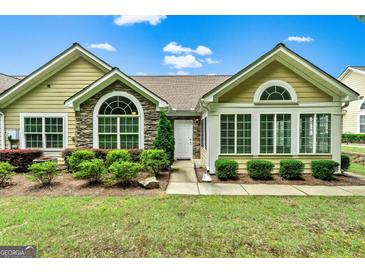 Charming home exterior featuring stone accents, many windows, and well-maintained landscaping at 140 Rehobeth Way, Fayetteville, GA 30214