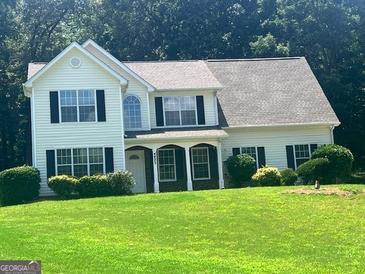 Charming two-story home with a well-manicured lawn and inviting curb appeal nestled among mature trees at 4489 Northwind Dr, Ellenwood, GA 30294