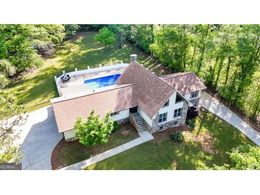 Stunning home showcasing backyard pool, lush landscaping, and stone elevation at 3222 Bay View Dr, Jonesboro, GA 30236