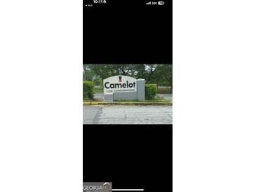 Sign for Camelot Club Condominiums amidst lush landscaping and trees at 1308 Camelot Dr, South Fulton, GA 30349