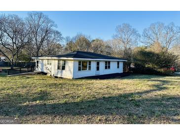 Quaint single-story home with white siding and a well-maintained yard at 225 Bell St, Covington, GA 30016
