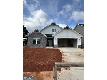 Charming new construction home featuring a stone facade and two-car garage at 11156 Cornerstone Way, Hampton, GA 30228