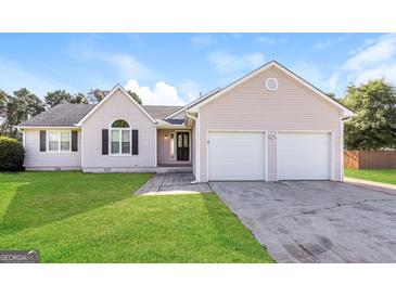 Charming single-story home with a well-maintained lawn and two-car garage at 11102 Hunters Ln, Hampton, GA 30228