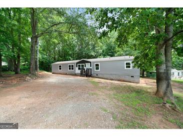 Exterior view of home with gray siding and wooded surroundings at 273 Ridge Dr, Villa Rica, GA 30180