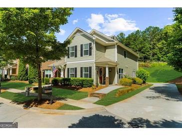 Charming two-story home features a well-manicured lawn, complemented by lush trees and beautiful landscaping at 397 Cypher Dr, Suwanee, GA 30024