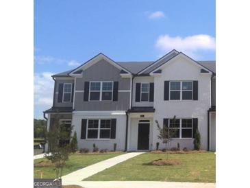 Modern two-story townhome featuring a well-manicured lawn and classic black shutters under a bright blue sky at 352 Sound Cir, Stockbridge, GA 30281