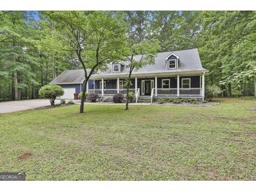 Charming home with a large, inviting front porch and well-manicured lawn surrounded by lush trees at 270 Carrolls Way, Fayetteville, GA 30215