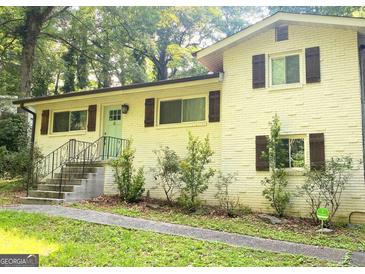 Charming home featuring a well-maintained yard, a light brick facade, and stylish shutters at 481 Meadowbrook Se Dr, Marietta, GA 30067
