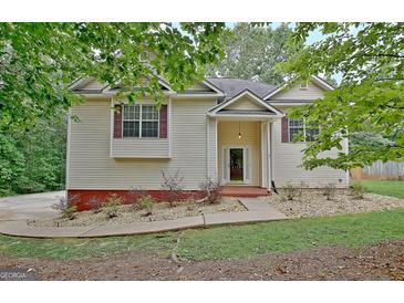 Charming home exterior with vinyl siding, mature trees, and well-maintained landscaping at 4135 Coursey Lake Rd, Douglasville, GA 30135