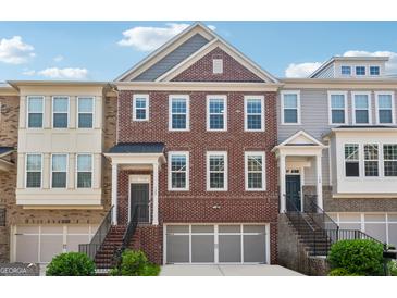 Charming townhome featuring a brick facade, attached garage, and welcoming entryways at 733 Wexford Cove Way, Mableton, GA 30126